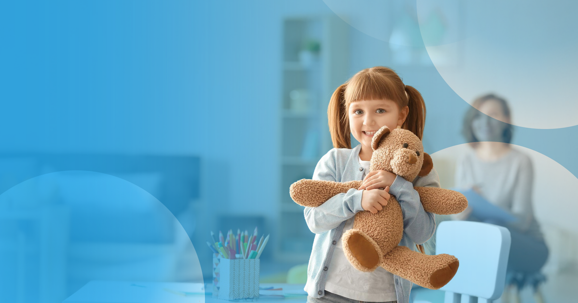Child hugging a teddy bear during a therapy session